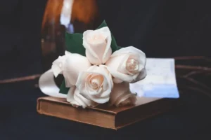 Urna funerária no ABC Paulista com arranjo de flores brancas sobre madeira.